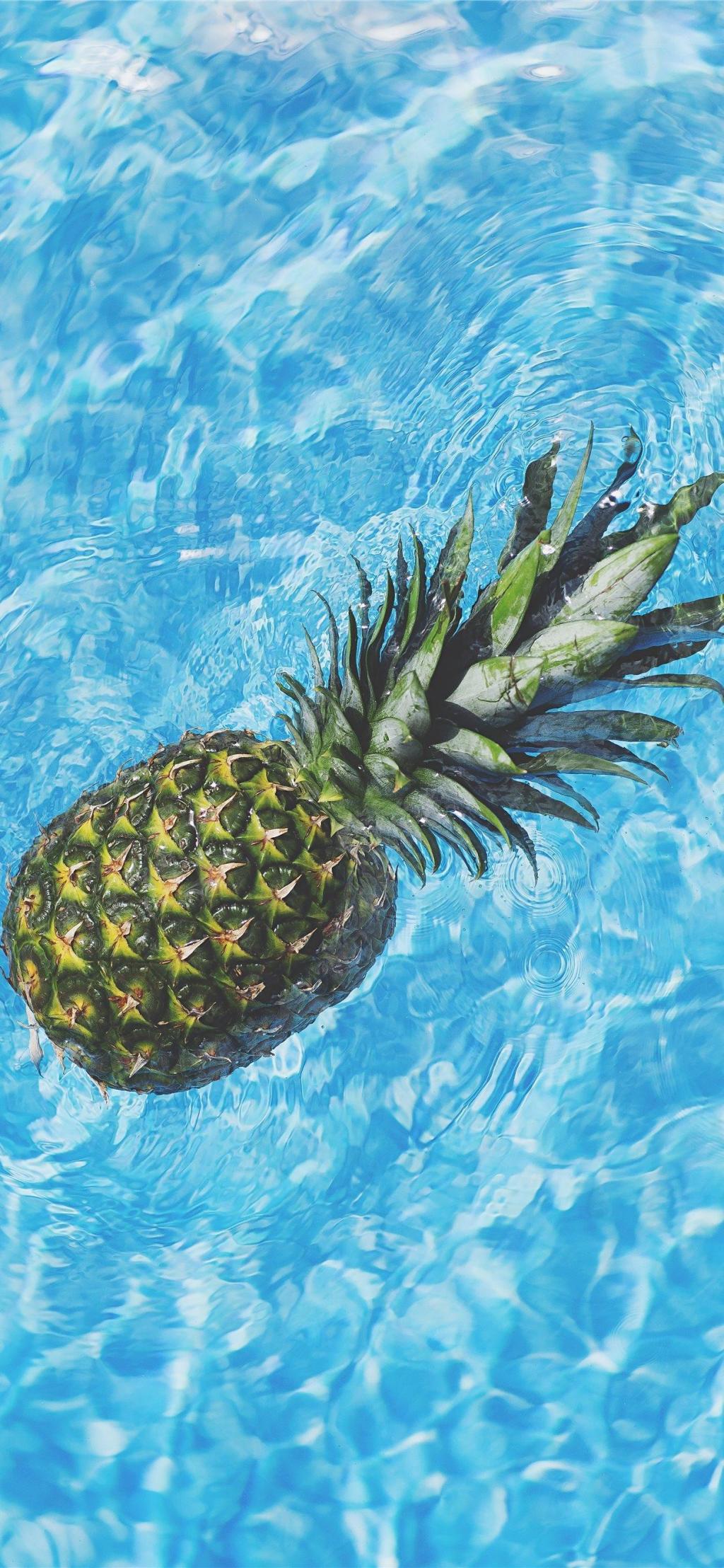 泳池里漂浮的菠萝手机壁纸